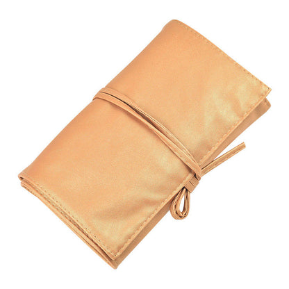 A shiny gold metallic makeup bag with a wrap-around tie closure, displayed against a white background by Sweet Deals.