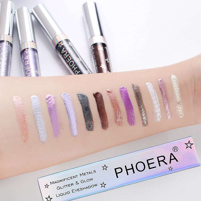 Arm displaying swatches of various long-lasting liquid eyeshadow shades, from pink to purple and gray, near tubes of Sweet Deals PHOERA Magnificent Metals Glitter and Glow Liquid Eyeshadows.