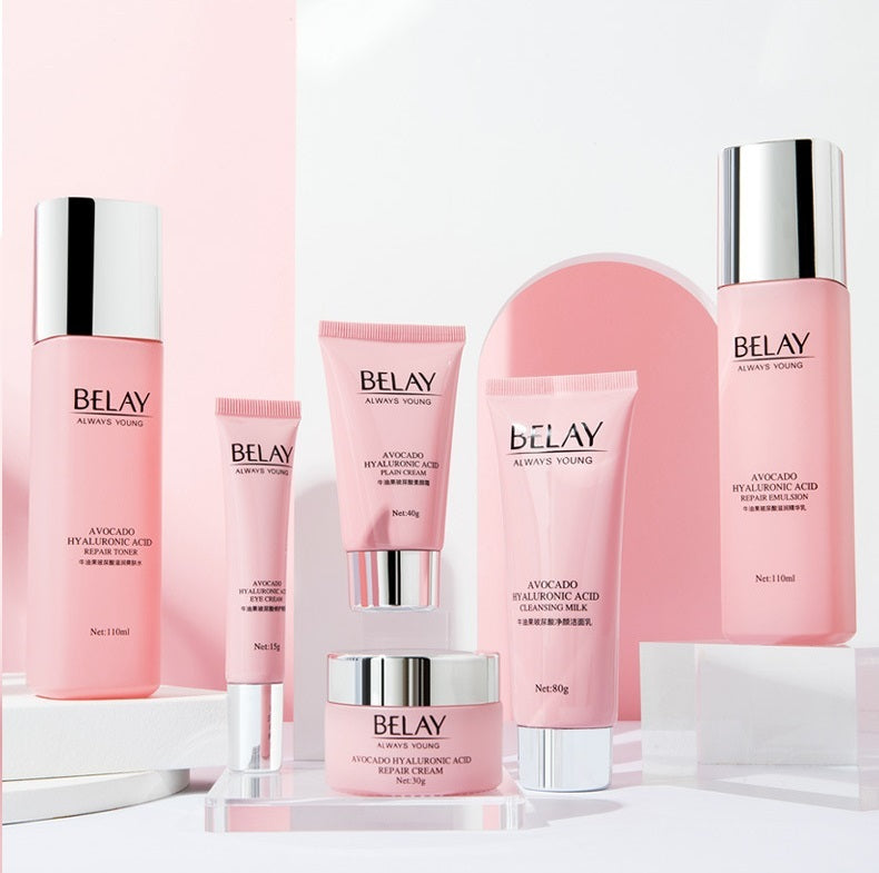 A collection of Sweet Deals Beauty Salon Facial Care Cosmetics, including toner, face cream, and serum in pink and white packaging, displayed against a pink background. This skin care set features moisturizing cream enriched with hy