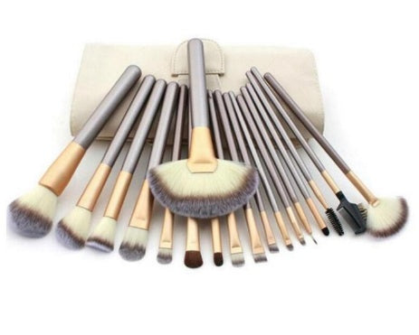 A set of Sweet Deals Persian Make-up Brush Suit Rice White Make Up Brushes, with champagne-colored handles and beige bristles, spread out on a white cloth.