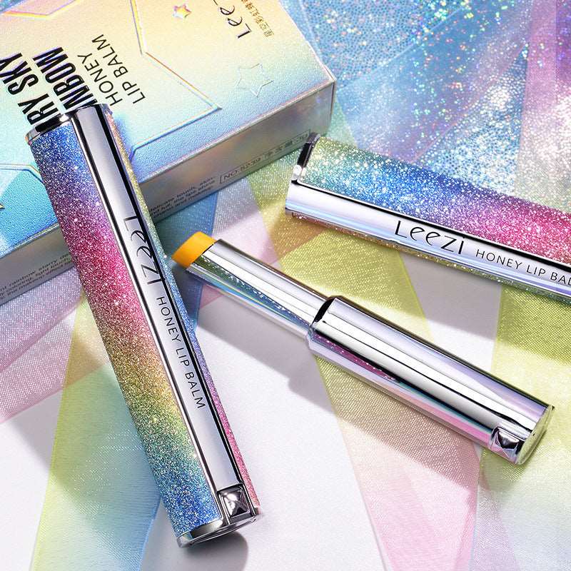Three Rainbow Star Color Changing Lipstick Warm Gradient Lipstick Honey Moisturizing Makeup tubes set against a background of colorful, holographic packaging with reflective surfaces, conveying a bright and glamorous makeup aesthetic by Sweet Deals.